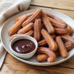 Sprøde churros med sukker og kanel på tallerken