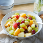 Frugtsalat med æbler, appelsiner, jordbær og druer