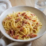 Pasta med bacon og cremet sauce toppet med persille